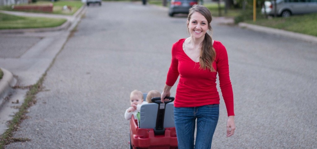 mom smiling while pulling babies in a wagon