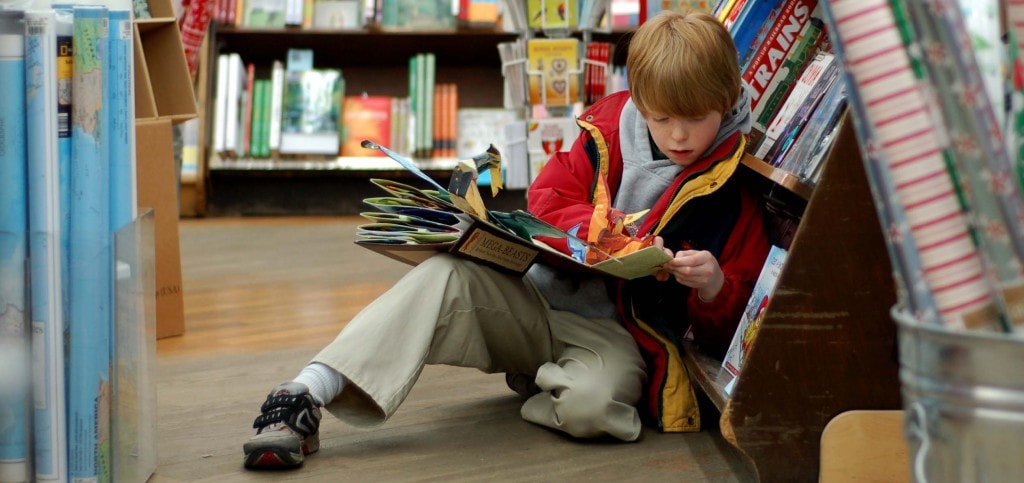 Boy reading a pop-up book in a bookstore